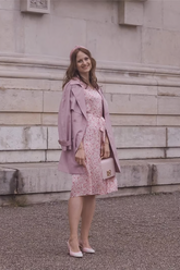a lady in a pink floral dress and a pink trench coat